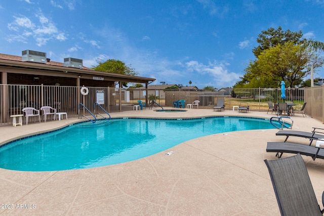 community pool featuring a patio area and fence