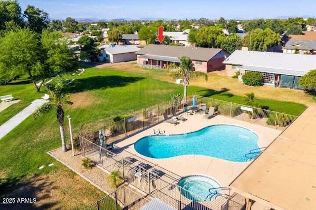 community pool featuring a lawn, a patio, and fence