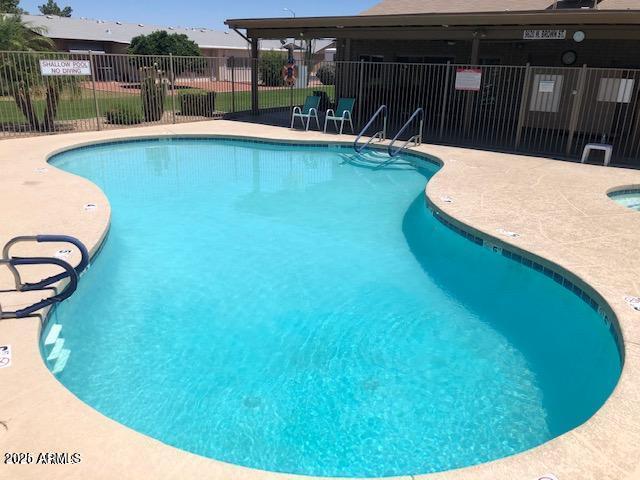 pool featuring fence and a patio
