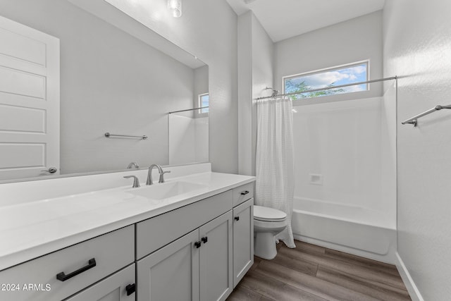 full bathroom with vanity, hardwood / wood-style flooring, shower / bathtub combination with curtain, and toilet