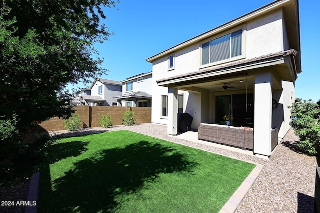 back of property with a lawn, outdoor lounge area, and ceiling fan