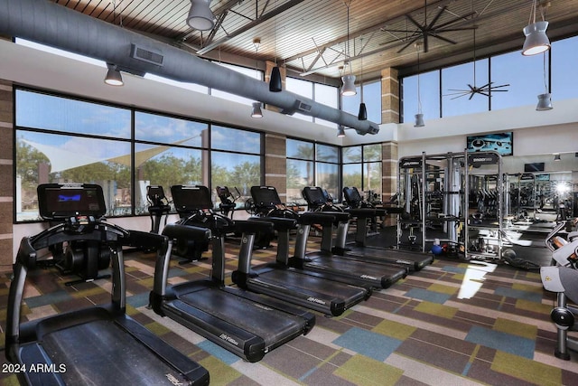 workout area with a towering ceiling and ceiling fan