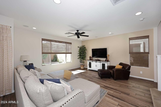 living room featuring ceiling fan and dark wood-type flooring