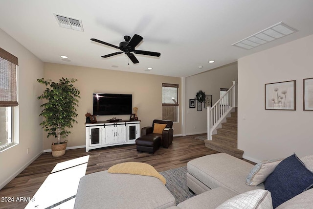 living room featuring ceiling fan and dark hardwood / wood-style floors