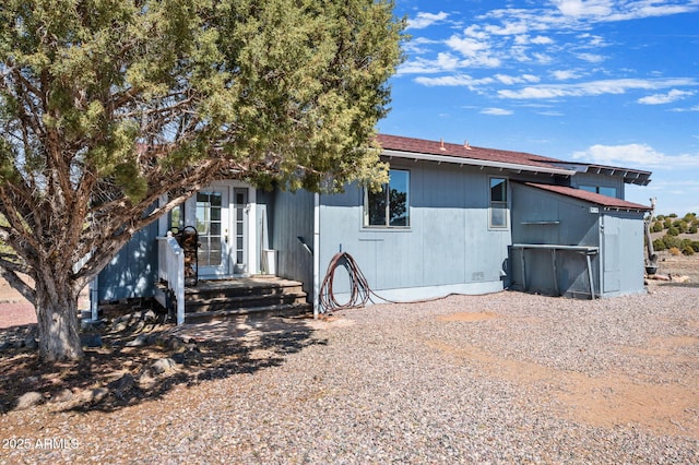 back of property with a shingled roof