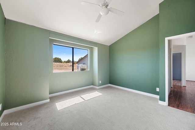 unfurnished room with baseboards, vaulted ceiling, carpet floors, and a ceiling fan