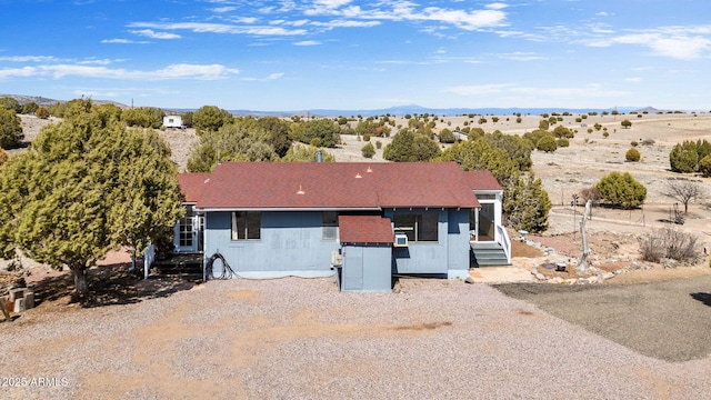 view of front of house with a shingled roof, gravel driveway, and entry steps