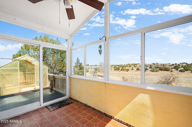 unfurnished sunroom with a ceiling fan
