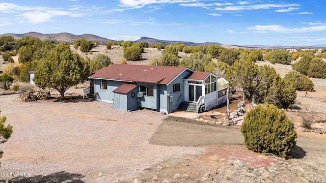view of front of house featuring driveway, a sunroom, and a mountain view