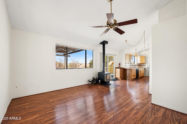 unfurnished living room featuring ceiling fan, a wood stove, and dark wood-style flooring
