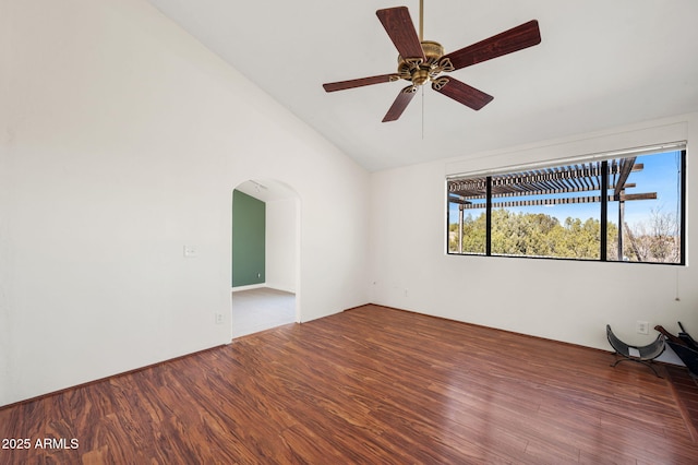 spare room with vaulted ceiling, arched walkways, ceiling fan, and wood finished floors