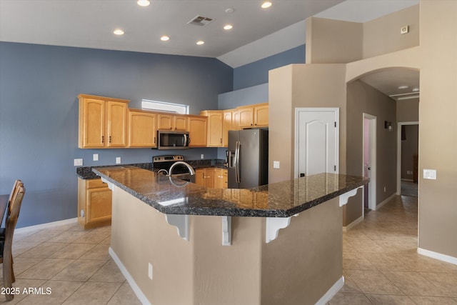 20464 E Bronco Dr, Queen Creek, AZ 85142 - kitchen with stainless steel appliances, light tile patterned flooring, high vaulted ceiling, arched walkways, and a breakfast bar area