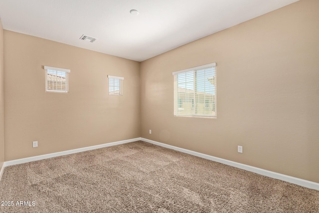 carpeted spare room with visible vents and baseboards