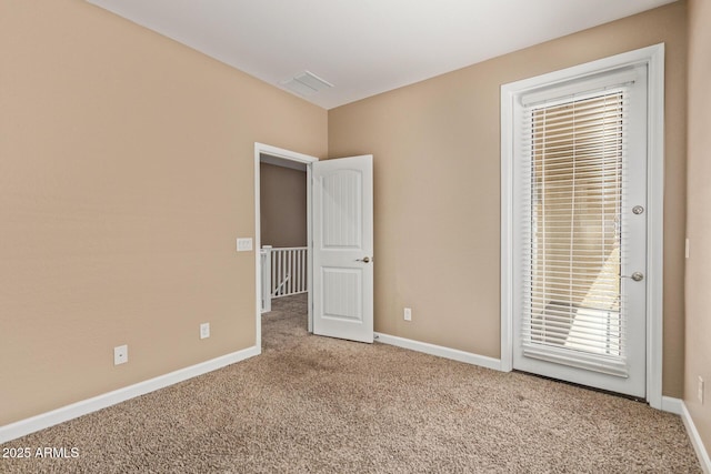 carpeted spare room with baseboards and visible vents