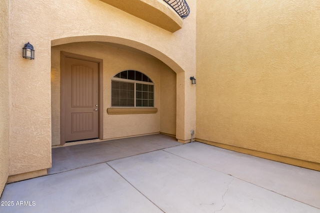 doorway to property with a patio area and stucco siding