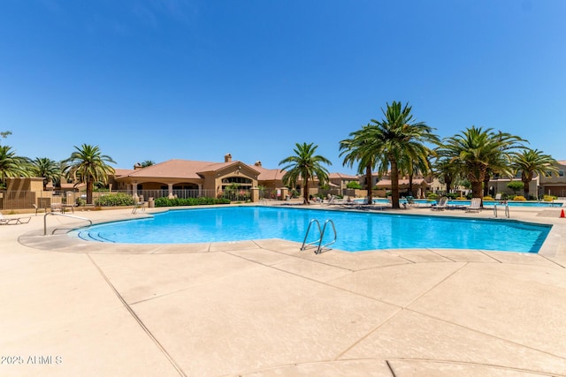 community pool featuring fence and a patio area