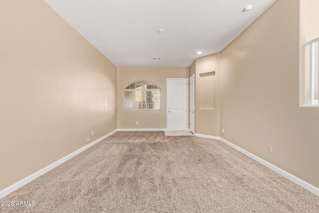 spare room featuring baseboards, light carpet, and recessed lighting