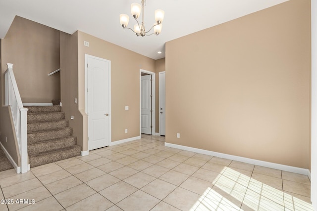 spare room featuring an inviting chandelier, stairs, baseboards, and light tile patterned floors