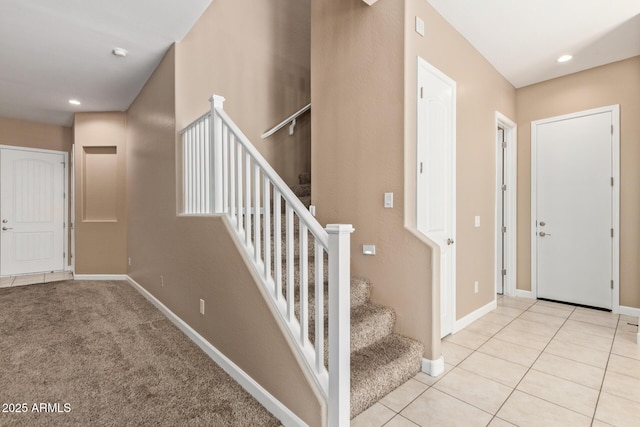 staircase with tile patterned floors, baseboards, and recessed lighting