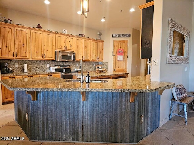 kitchen featuring tasteful backsplash, a breakfast bar, stainless steel appliances, and sink