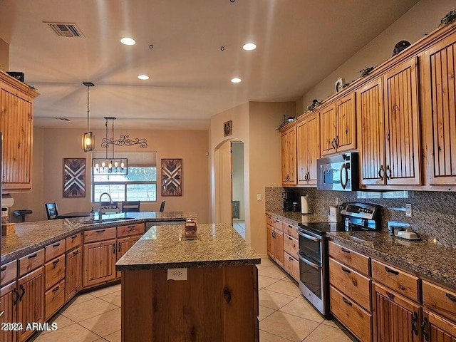 kitchen featuring decorative backsplash, stainless steel appliances, sink, a center island, and hanging light fixtures