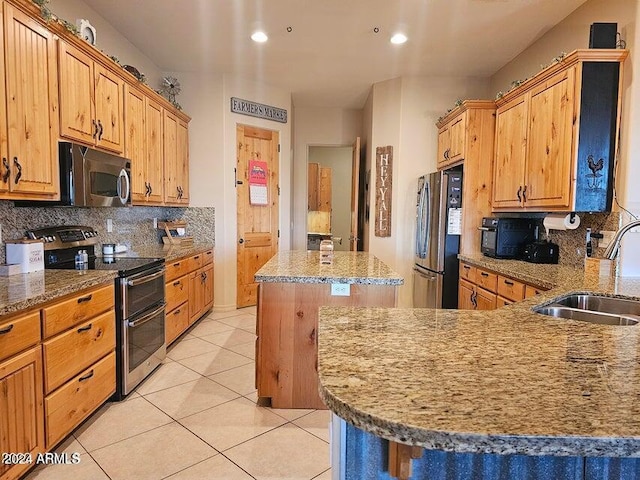 kitchen with a kitchen island, sink, appliances with stainless steel finishes, and tasteful backsplash