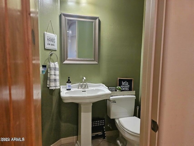 bathroom with tile patterned flooring, toilet, and sink