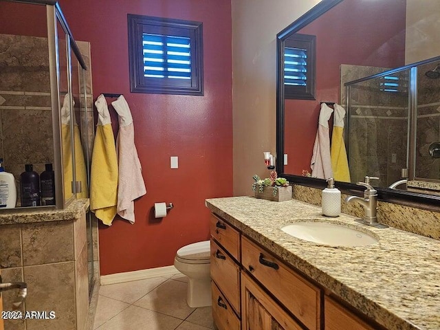 bathroom featuring tile patterned flooring, vanity, a shower with door, and toilet