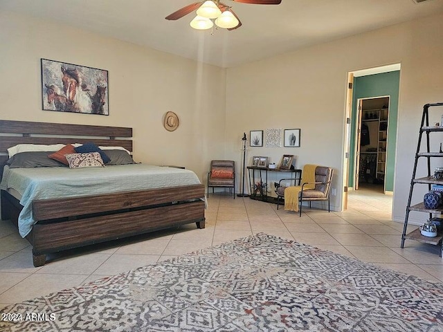 tiled bedroom featuring ceiling fan and a spacious closet