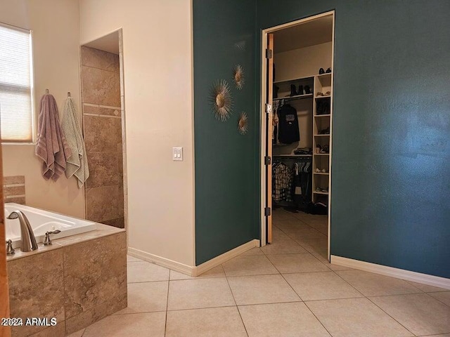 bathroom with tile patterned flooring and a relaxing tiled tub