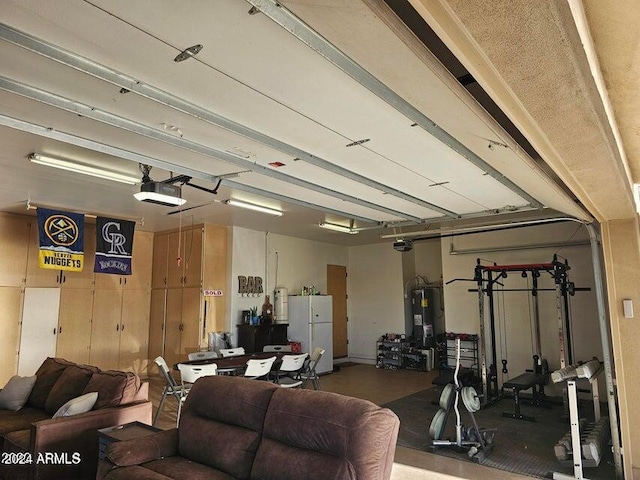 interior space with electric water heater, a garage door opener, and white refrigerator