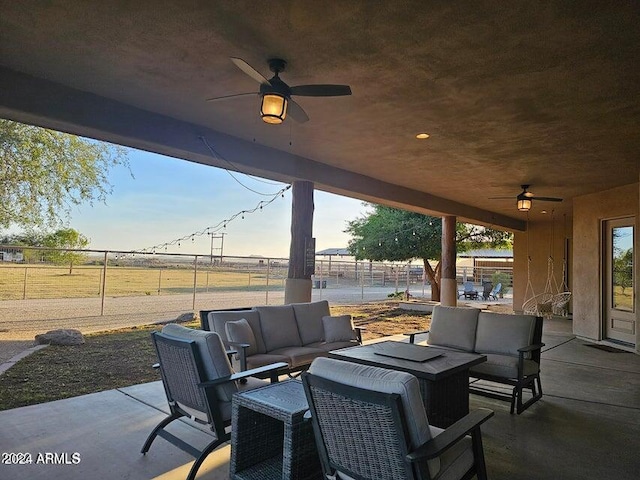 view of patio / terrace featuring outdoor lounge area, ceiling fan, and a rural view