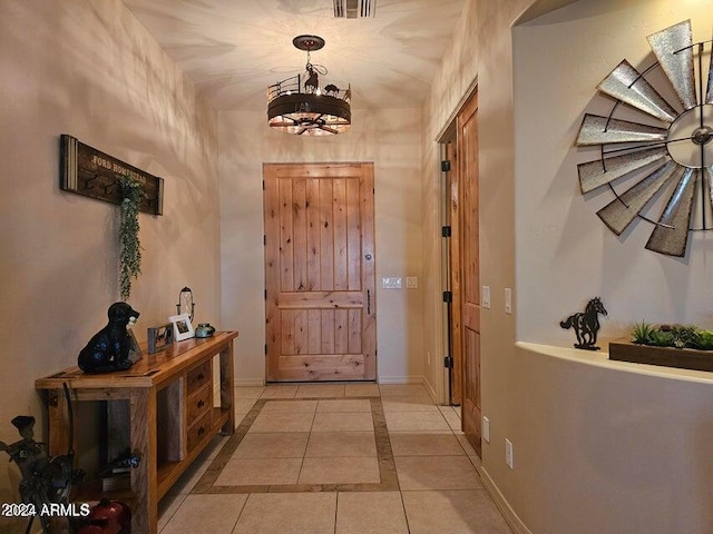 doorway to outside featuring light tile patterned floors and a notable chandelier