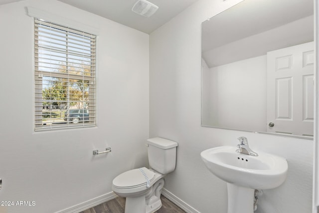 bathroom featuring hardwood / wood-style flooring, toilet, and sink