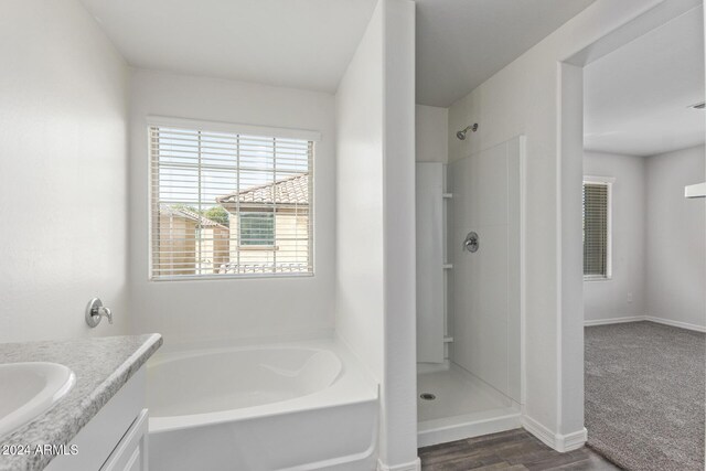 bathroom featuring hardwood / wood-style floors, vanity, and separate shower and tub