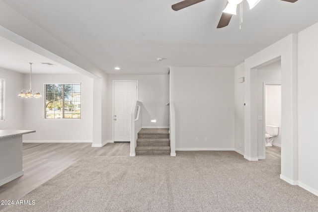 interior space featuring light wood-type flooring and ceiling fan with notable chandelier