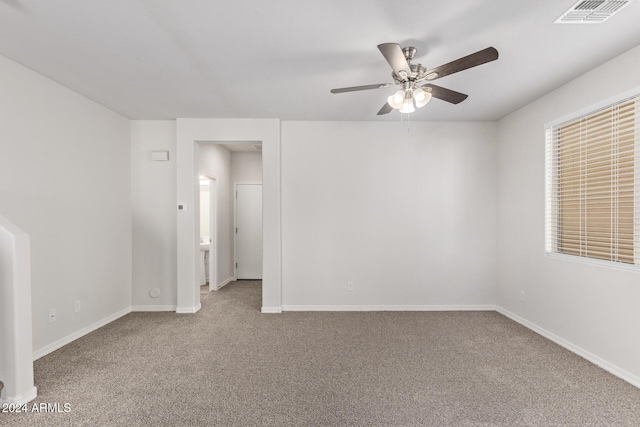 empty room featuring ceiling fan and carpet