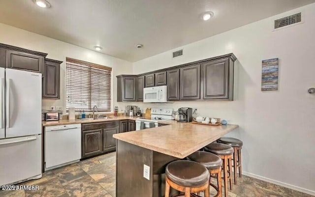 2600 W Old Linden Rd, Show Low, AZ 85901 - kitchen featuring white appliances, a sink, a breakfast bar, and dark brown cabinetry
