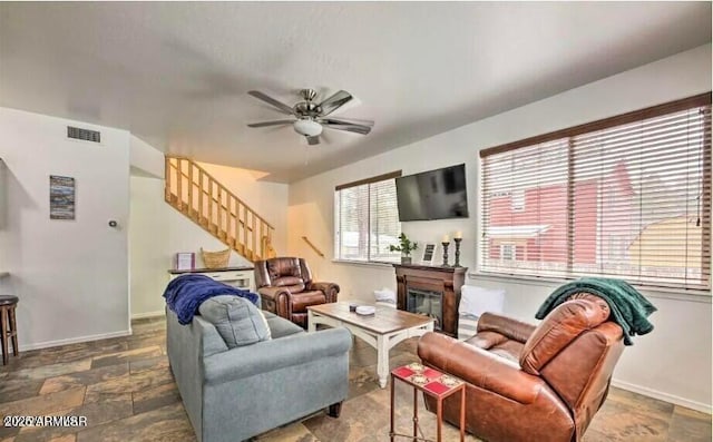2600 W Old Linden Rd, Show Low, AZ 85901 - living room with stairway, a ceiling fan, a glass covered fireplace, and baseboards