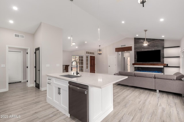 kitchen featuring a sink, an island with sink, white cabinetry, a ceiling fan, and stainless steel dishwasher