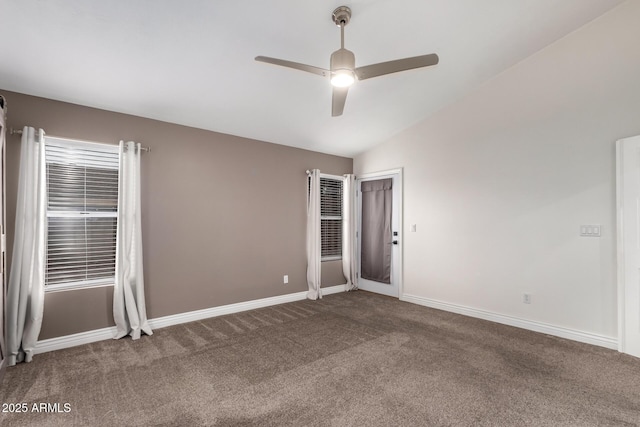 spare room with vaulted ceiling, carpet flooring, a ceiling fan, and baseboards