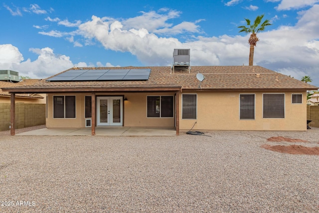 rear view of house with a patio area, stucco siding, french doors, and fence