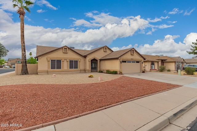 ranch-style house with an attached garage, driveway, and stucco siding