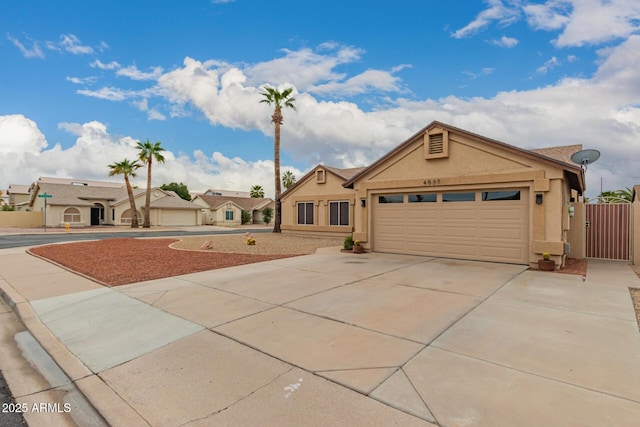 ranch-style house featuring stucco siding, a garage, concrete driveway, and a gate