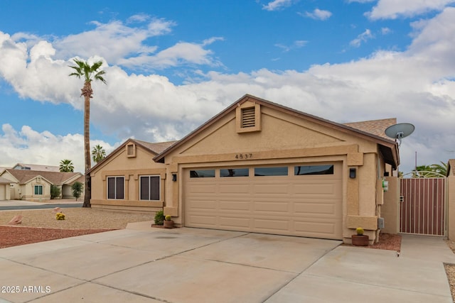 ranch-style house with concrete driveway, a gate, a garage, and stucco siding