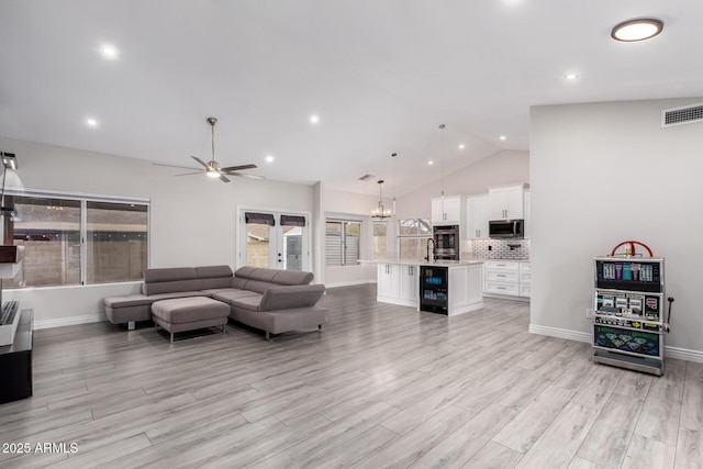 living area featuring visible vents, beverage cooler, ceiling fan with notable chandelier, recessed lighting, and light wood-style floors