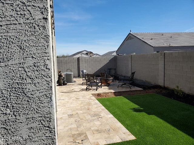 view of yard featuring central AC, a patio, and an outdoor fire pit