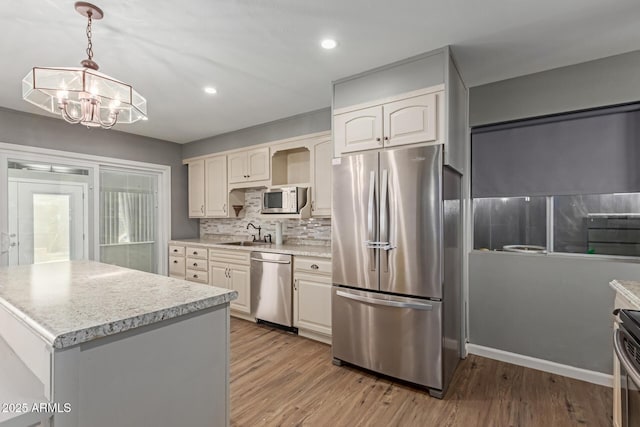 10001 W Caron Dr, Sun City, AZ 85351 - kitchen featuring stainless steel appliances, a sink, a chandelier, light wood-type flooring, and recessed lighting