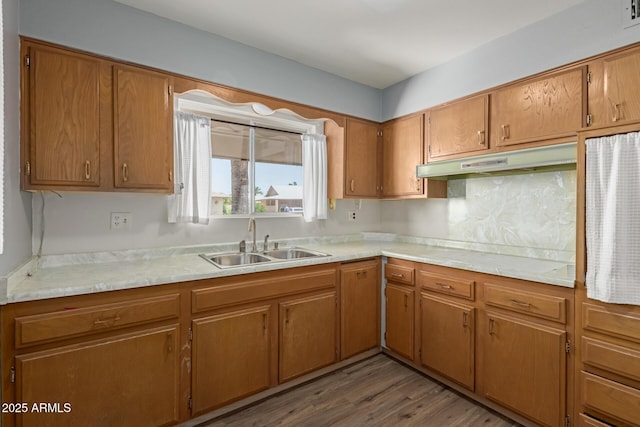 10001 W Caron Dr, Sun City, AZ 85351 - kitchen featuring a sink, under cabinet range hood, light countertops, wood finished floors, and brown cabinets