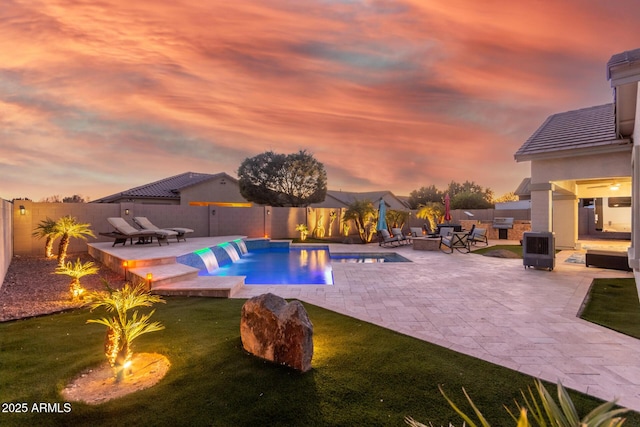 pool at dusk featuring a patio area